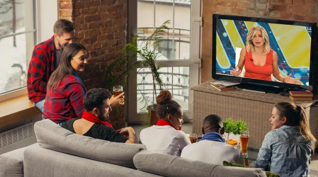 Grupo de amigos viendo televisión española en directo